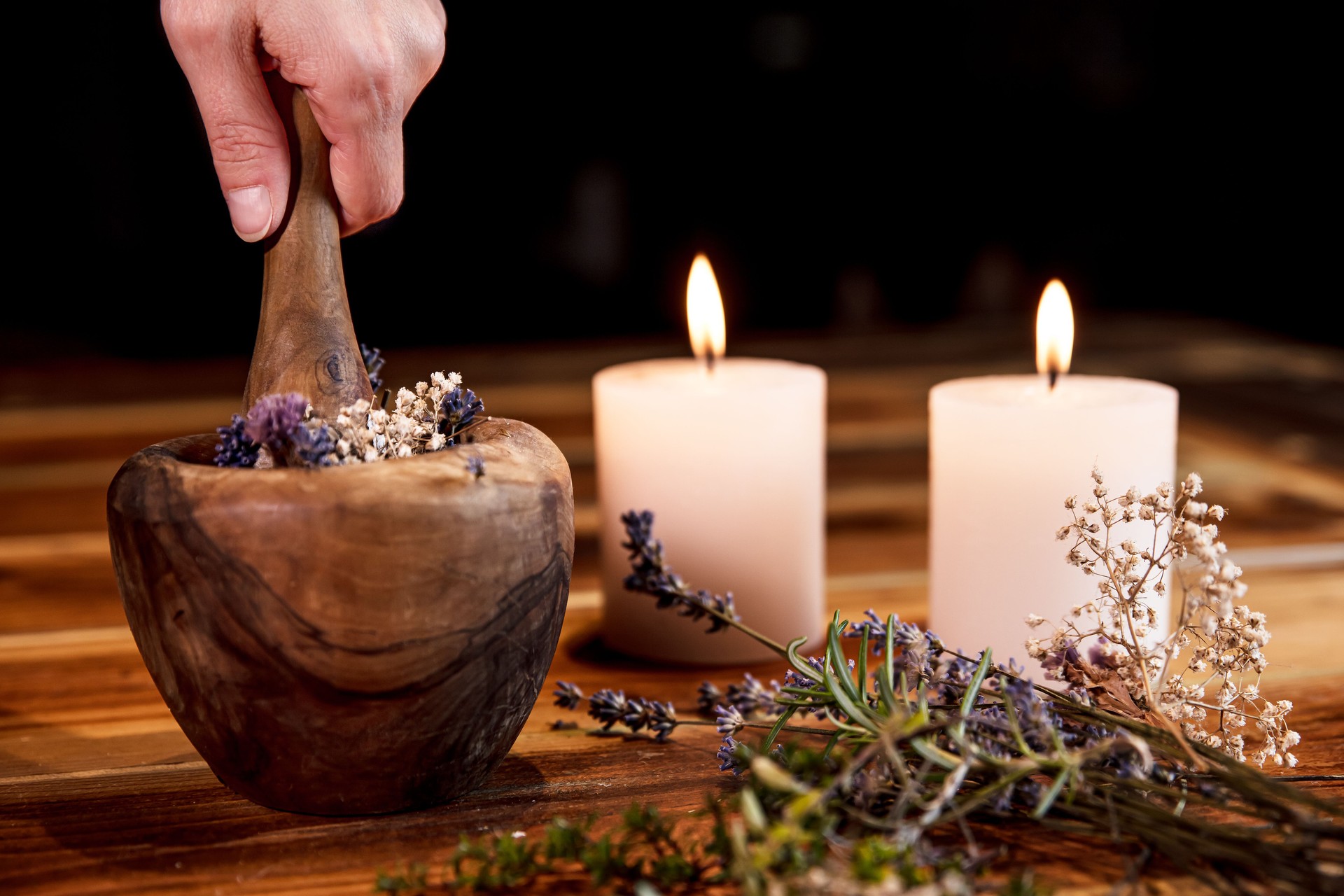 Woman is pulverising healing herbs and flowers into a mortar, ritual cleansing and purification